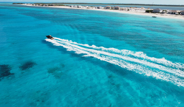 Aerial photo of the VOLTARI 260 in Ballistic charcoal riding through the clear blue waters of Bimini, Bahamas